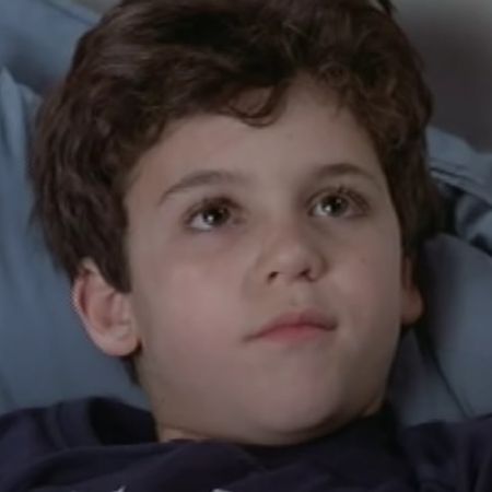 Young Fred Savage is lying on the bed.